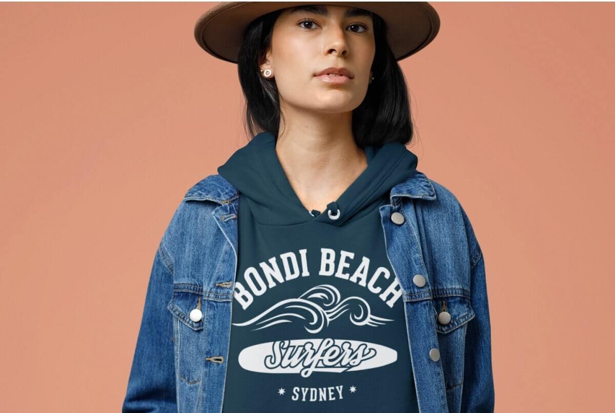 An image of a woman wearing a hoodie that says “Bondi Beach Surfers Sydney”