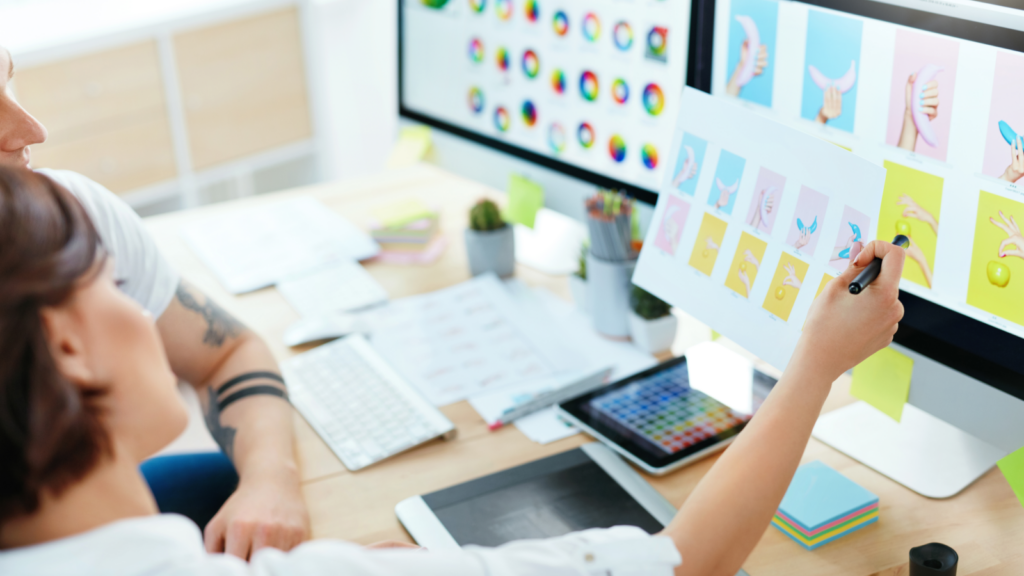 A man and woman collaborate on a computer, surrounded by vibrant icons representing various applications and tools.