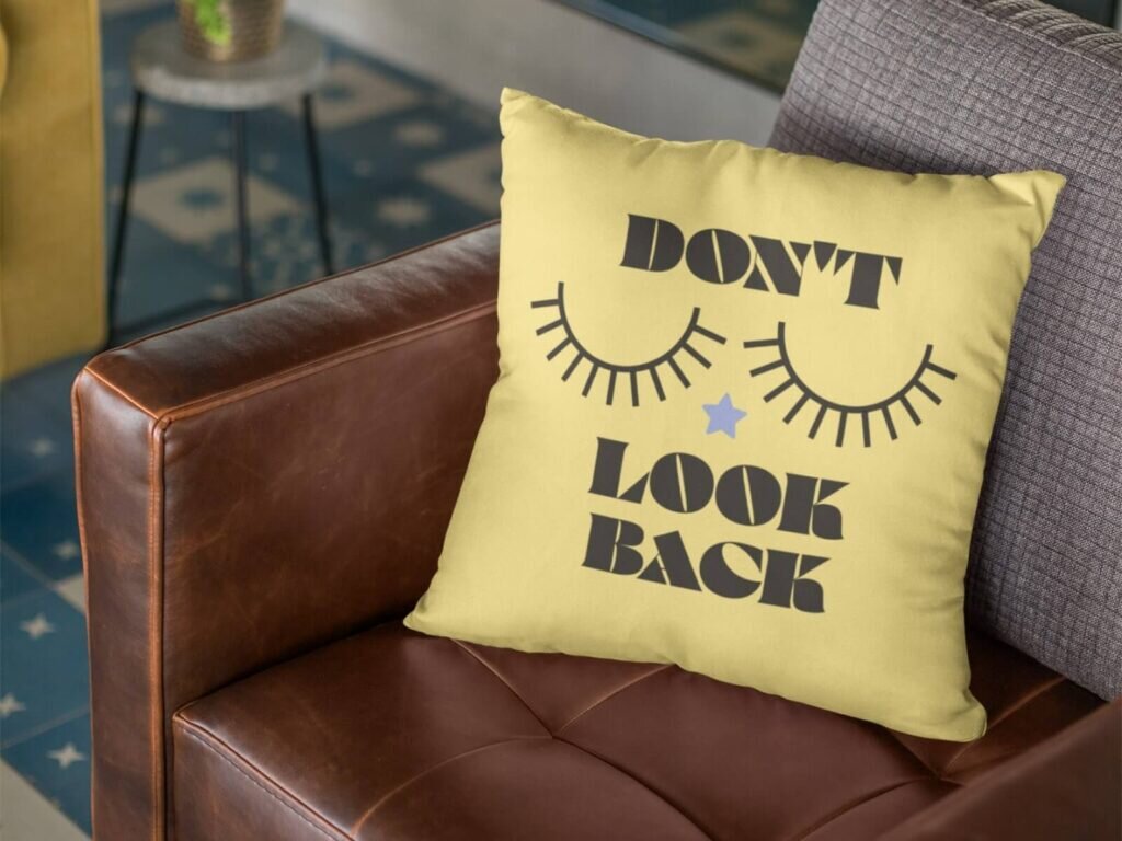 A custom yellow throw pillow with a “Don’t look back” print.
