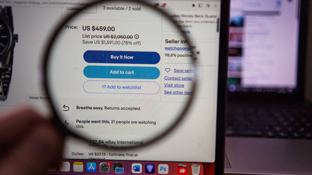 An eBay listing on a laptop screen under a magnifying glass.