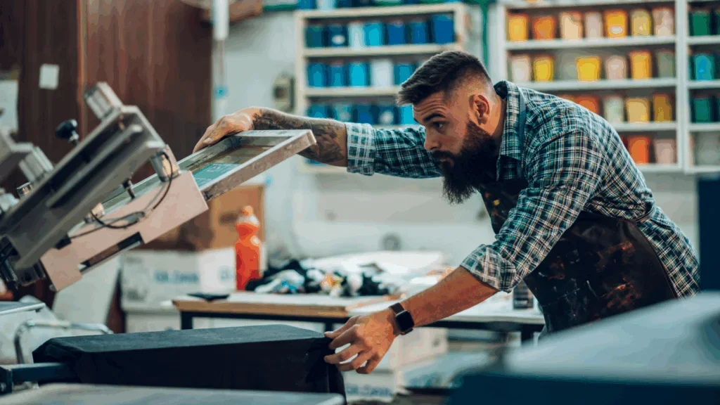 A man is making a print on a fabric.
