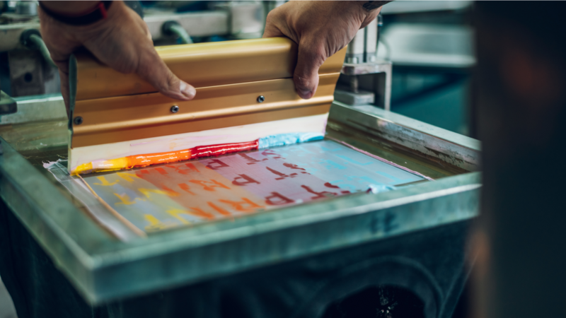 The process of custom t-shirt printing using screen printing.