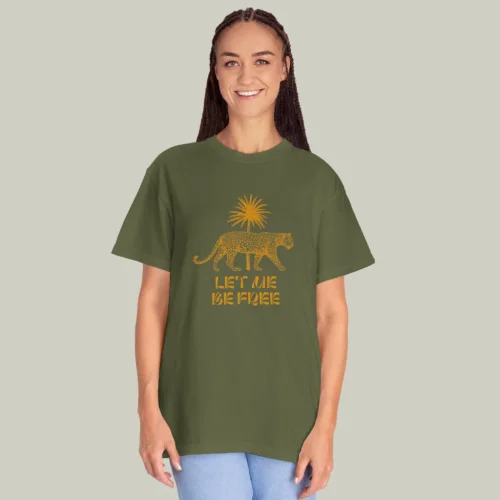 A woman wearing an olive and gold “Let me free” t-shirt on a light olive green background.