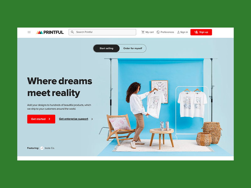 Printful homepage showing a woman holding a printed T-shirt in a studio.