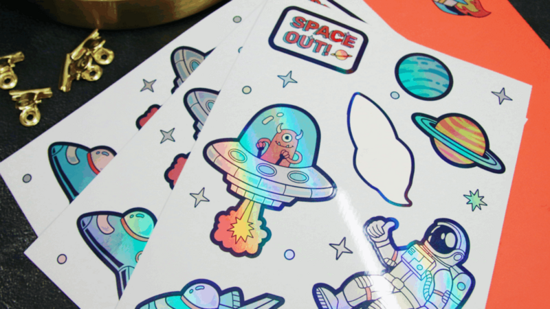 A collection of colorful space-themed cutout stickers featuring planets, stars, and rockets on a white background.