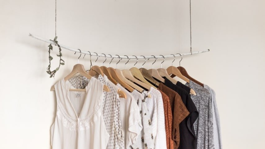 Clothes hanging on a white clothing rack.