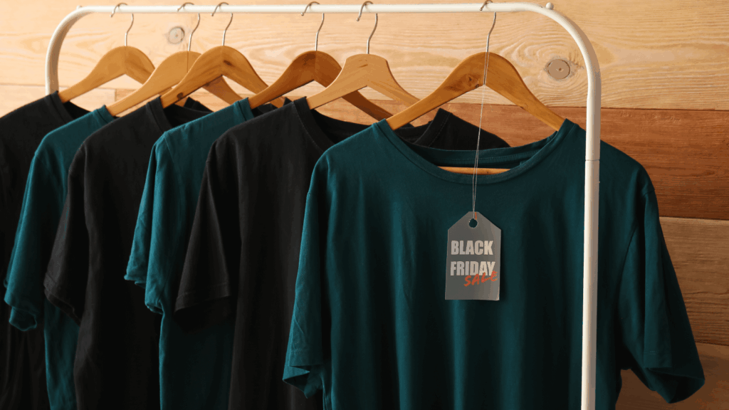 Black Friday t-shirts displayed on hangers, showcasing various designs and colors for holiday shopping.