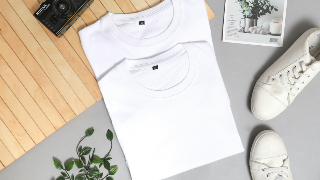 Two white t-shirts on a desk