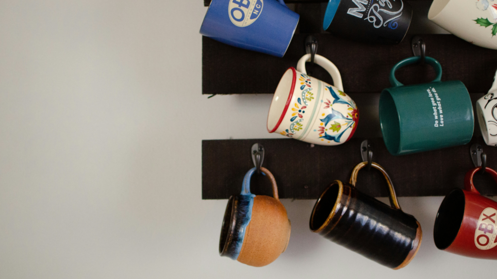 A collection of coffee cups displayed on a wall, showcasing different designs and sizes.