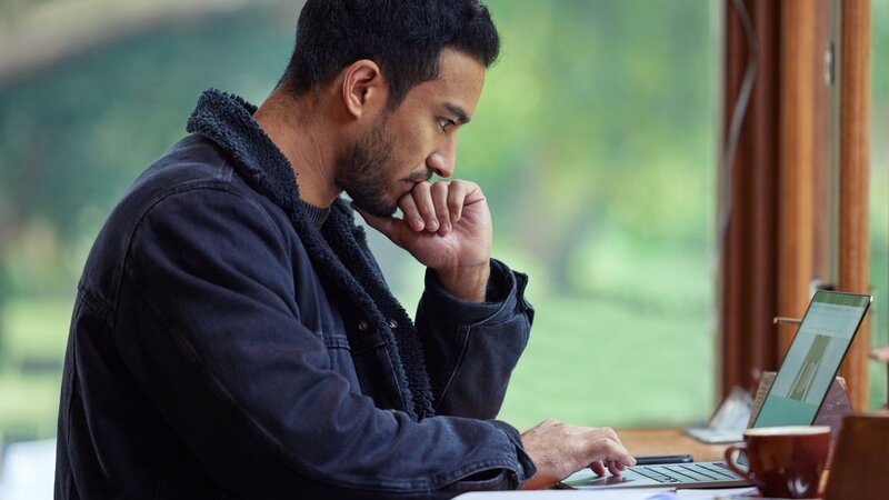 A man using social media apps on his phone to promote his clothing line.