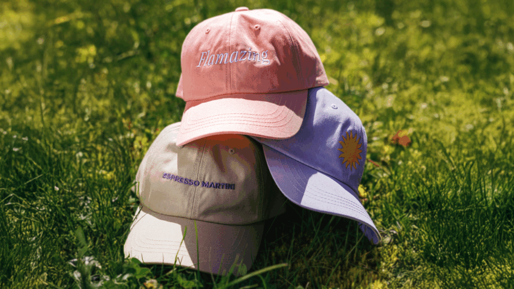 Custom hats in various colors with embroidered logos and text.