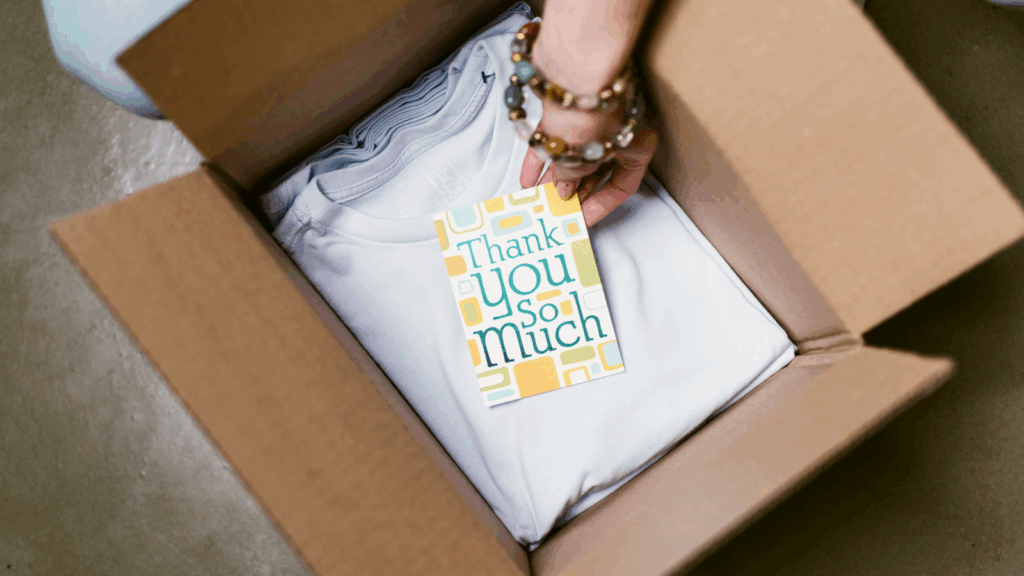 A t-shirt and a card featuring the phrase "Thank You So Much" in bold, colorful letters on a plain background.