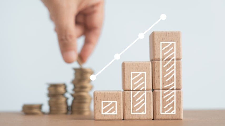 A person stacking up coins and wooden blocks in towers.