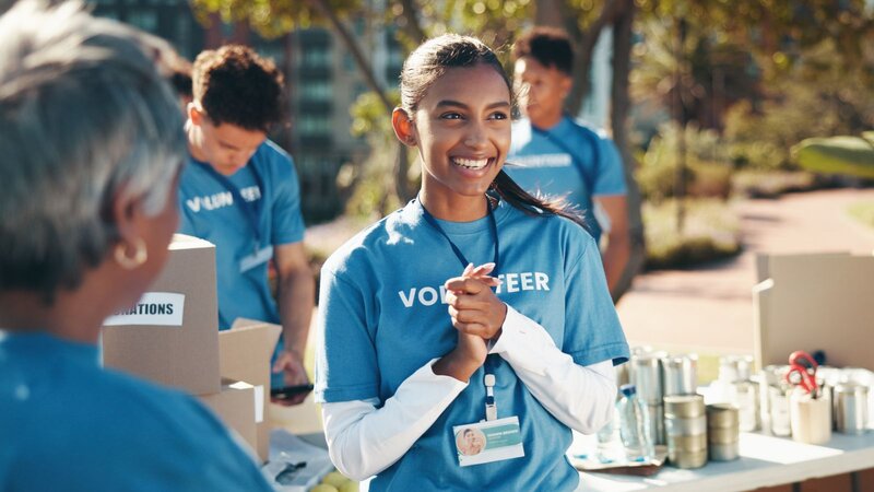 A volunteer is standing and smiling