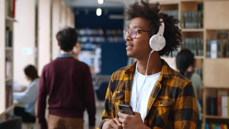 A student listening to music in a library.