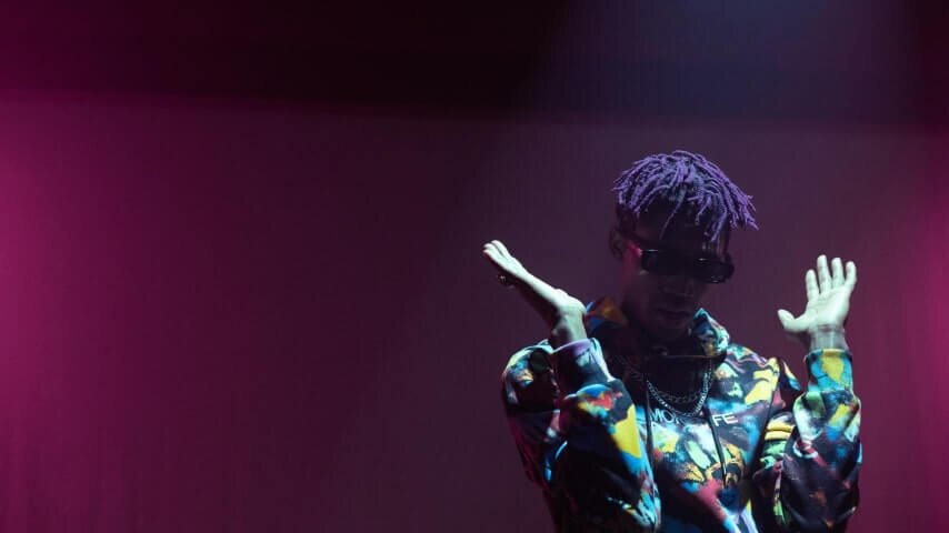 A man wearing a custom hoodie on a purple background.