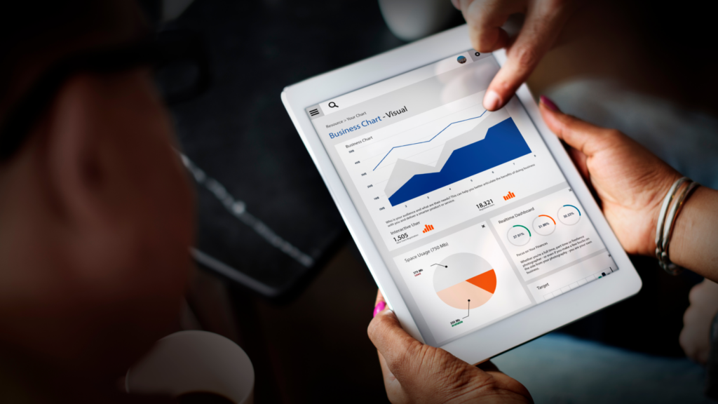 A person holding a tablet displaying a colorful graph, analyzing data in a professional setting.