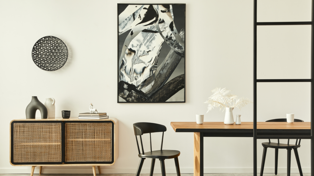 A black and white painting is displayed above a dining table, enhancing the room's aesthetic with its artistic presence.