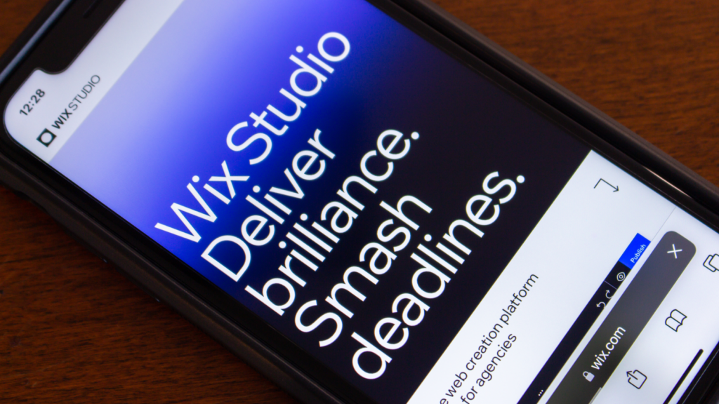 A smartphone displaying the "Wix Studio" on its screen, set against a neutral background.