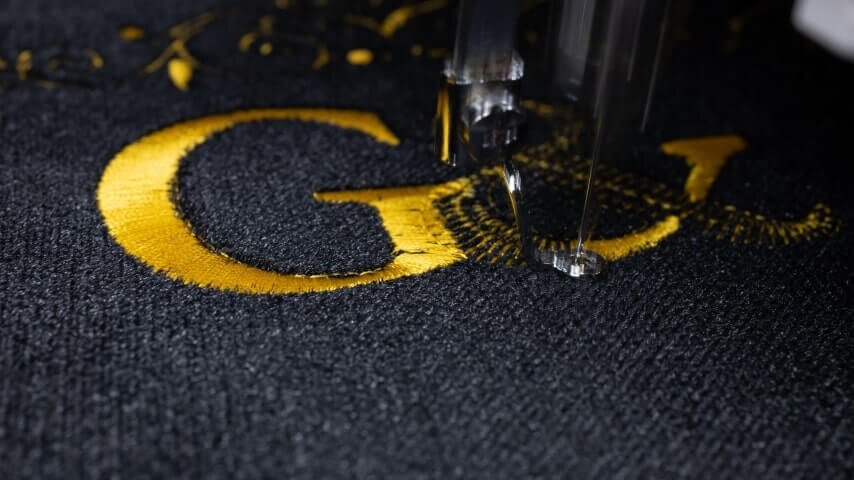 A custom logo is being embroidered.