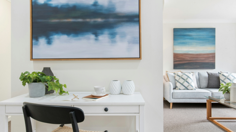 A room with a couple of canvases hanging on the walls.