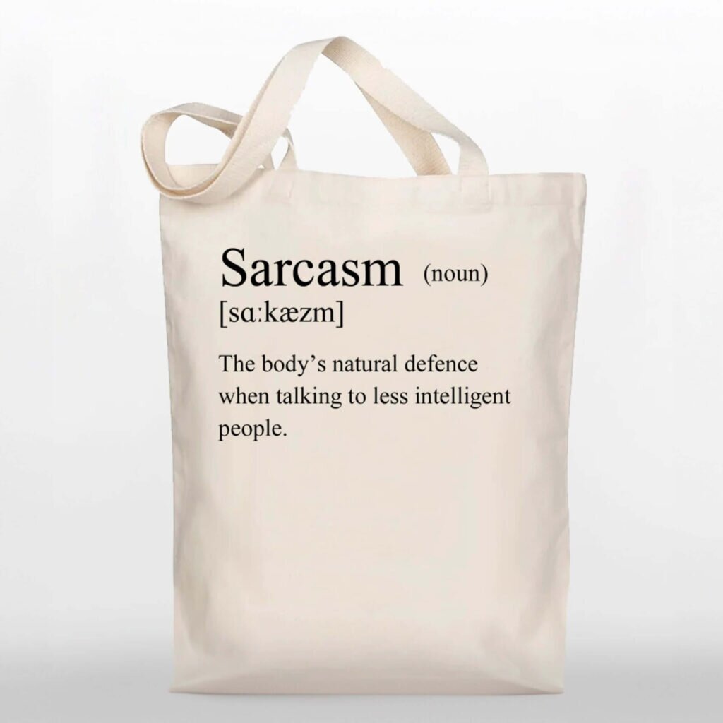 A tote bag with a definition for the word “Sarcasm” – The body’s natural defense when talking to less intelligent people.
