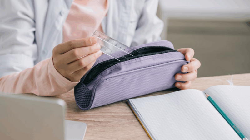 A person is holding a pencil case.