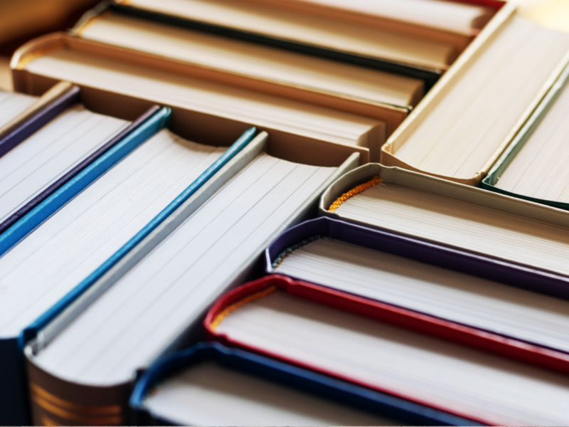 Hardbound books neatly arranged in stacks, creating a warm and inviting bookstore atmosphere.