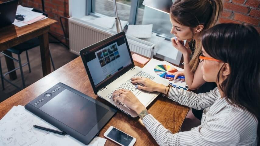 A woman working on image adaption for her Shopify store.