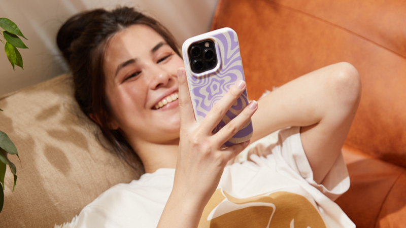 A woman using a phone with a custom phone case.