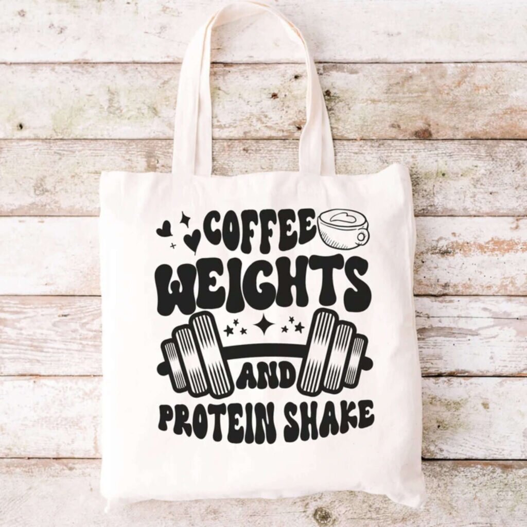 A tote bag with the text “Coffee, weights, and protein shake.”