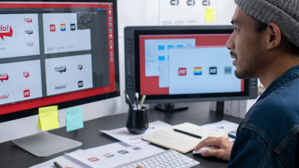 A man focused on a computer screen displaying multiple icons, engaged in work-related tasks.