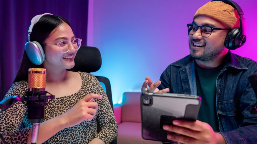 A man and woman with headphones communicating with each other, discussing gaming topics.