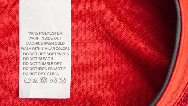 A red sweater with a 100% polyester label.