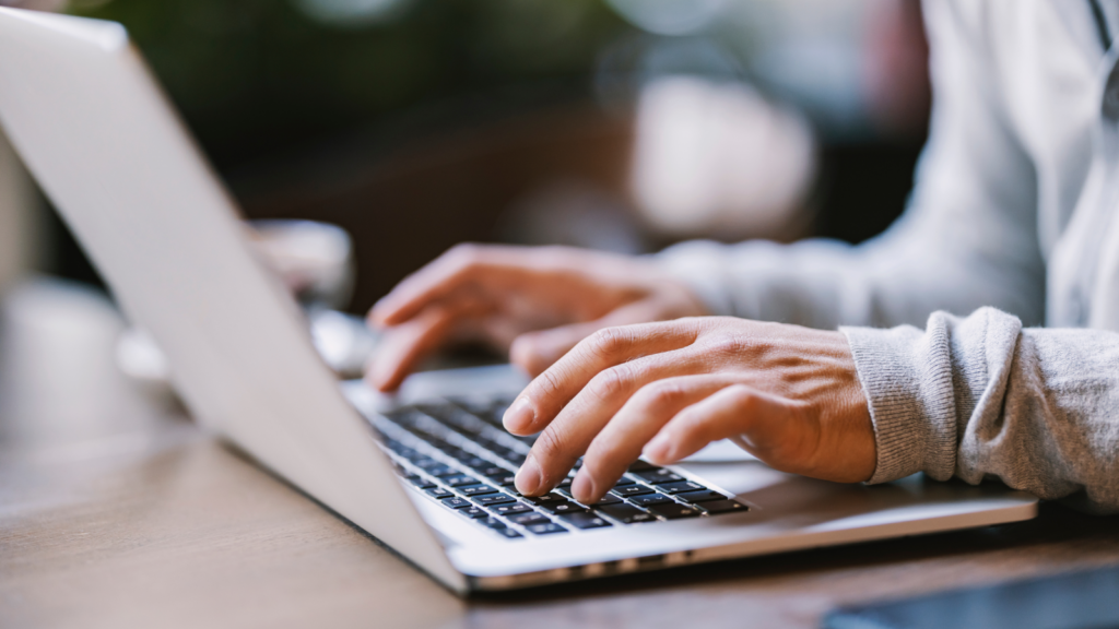 A person’s hands above a laptop keyboard.