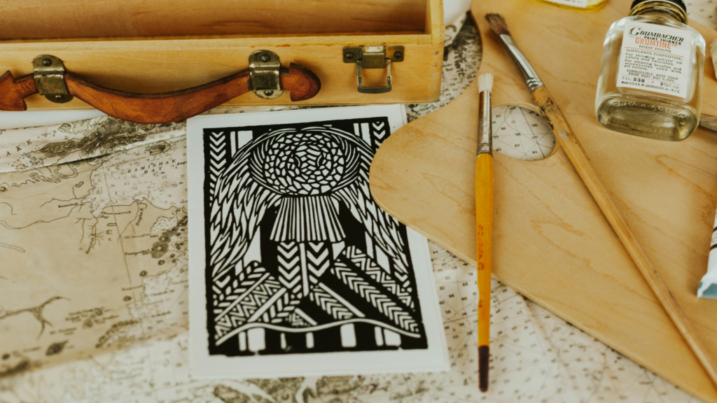 A piece of artwork next to some paintbrushes.