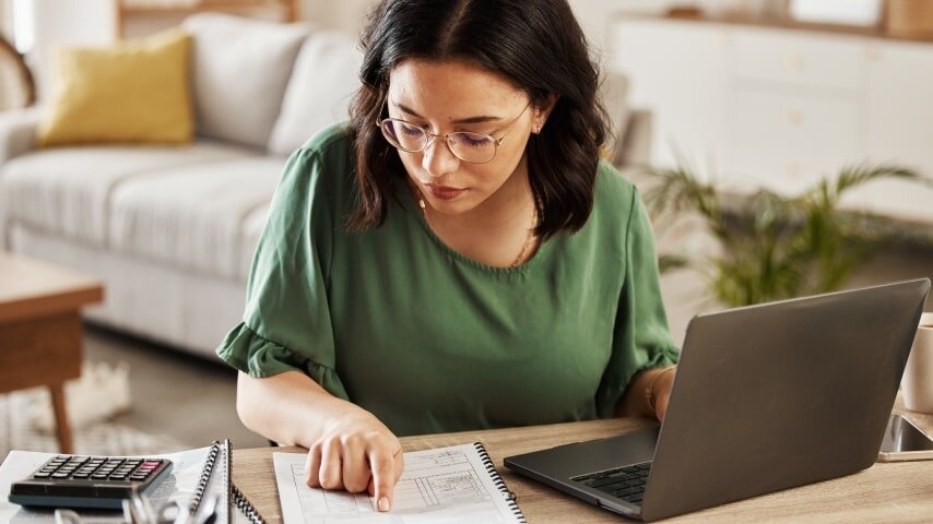 A woman sitting at a desk and doing her taxes.