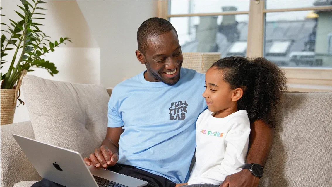 Father and daughter looking at a laptop