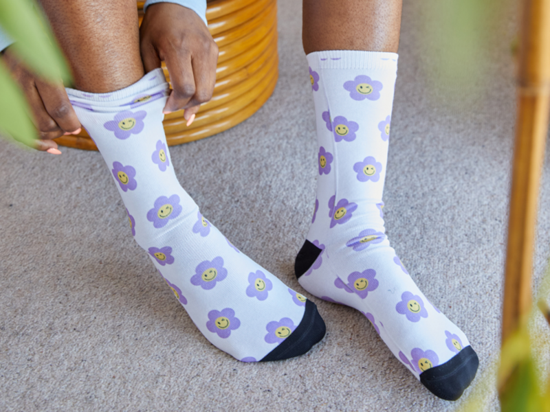 Socks: A woman is wearing vibrant purple and white flower-patterned socks, showcasing a stylish and colorful accessory.