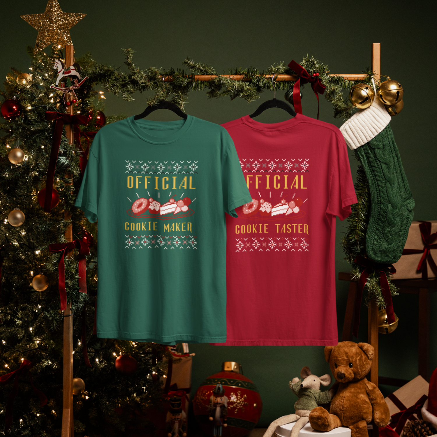 Two festive T-shirts hang on a wooden rack adorned with garland.