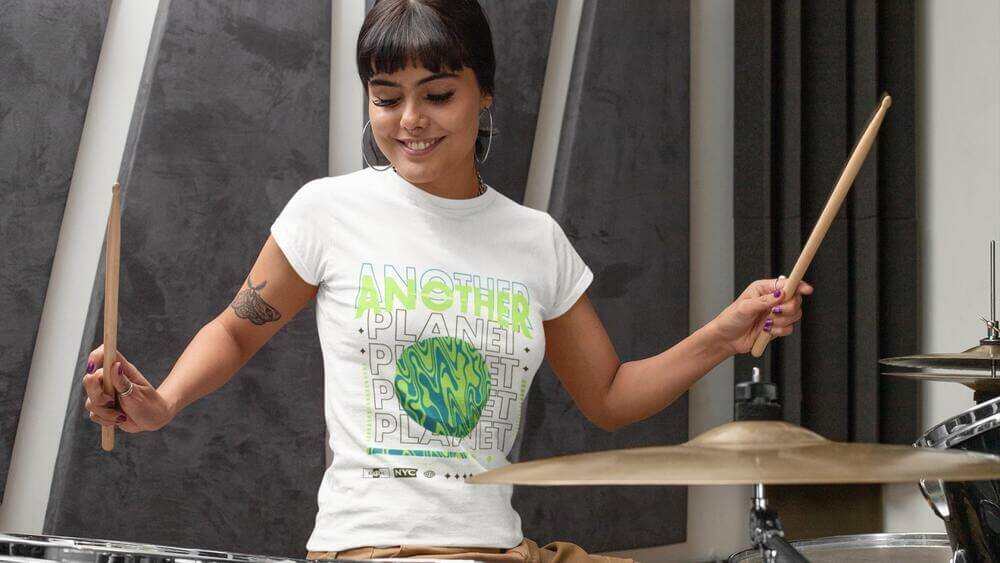 A young woman playing dreams and wearing a custom white Gildan 64000L t-shirt with an illustrated text print.