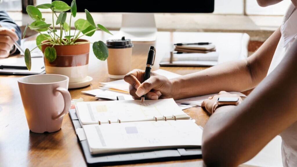 A woman sitting at a desk and taking notes.