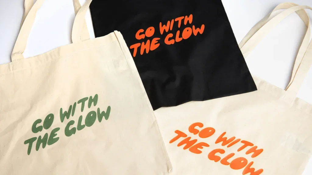 Three custom “Go with the glow” tote bags for a person starting a print-on-demand business.