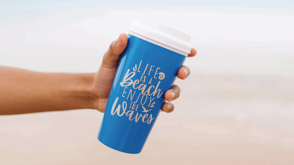 Hand holding a blue travel mug mockup against a neutral background, showcasing its design and color.