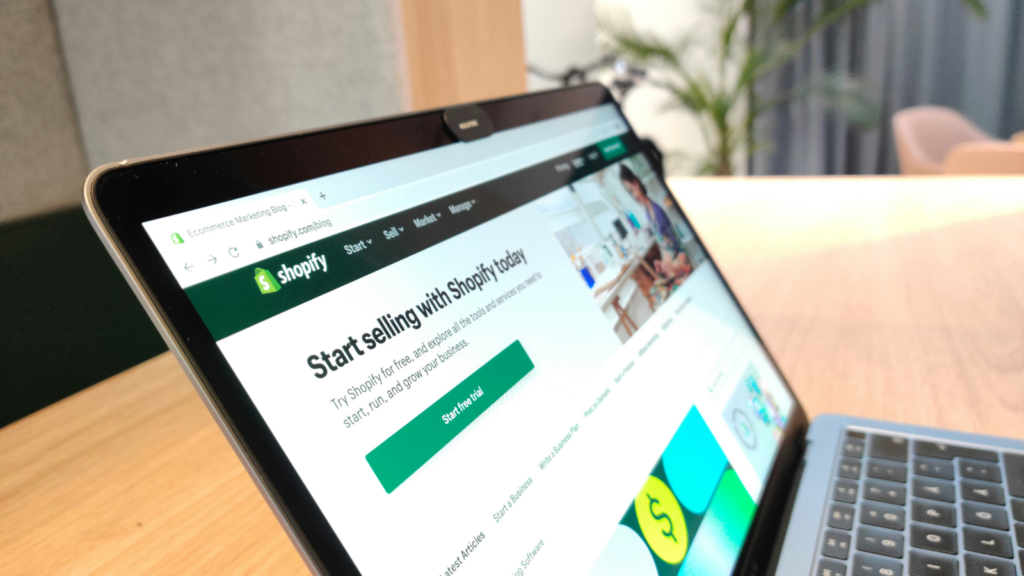 A corner shot of a laptop screen with Shopify’s homepage open.