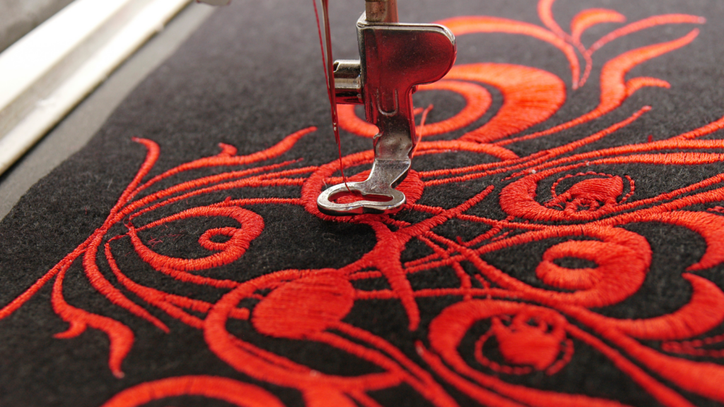 Close-up of a sewing machine featuring a striking red and black design, highlighting its intricate details and craftsmanship.