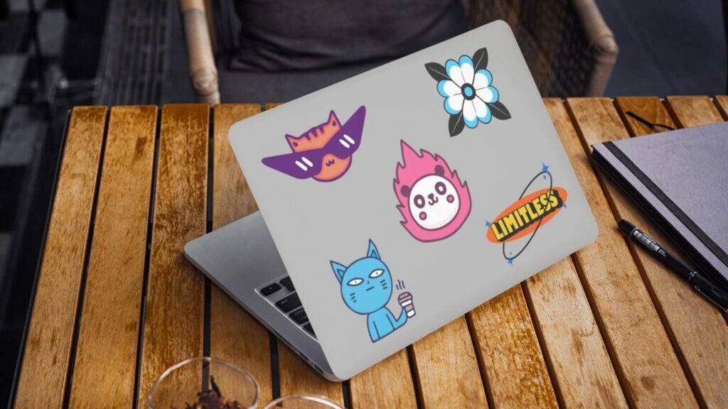 A laptop with 5 different stickers on it.