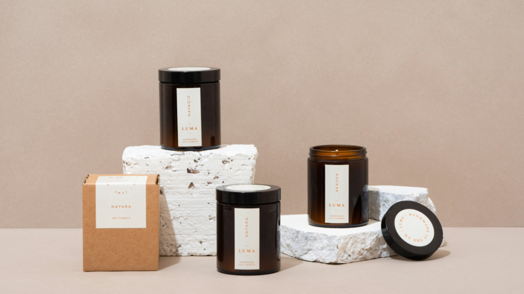Four colorful candles resting on a white block, creating a striking contrast with the simplicity of the background.