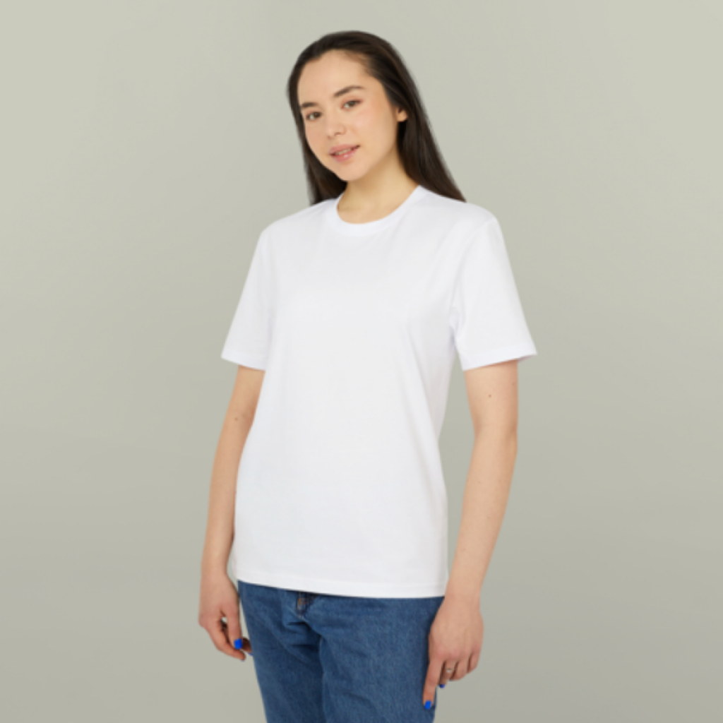A person with long dark hair wears a plain white T-shirt and blue jeans, standing against a light grey background.