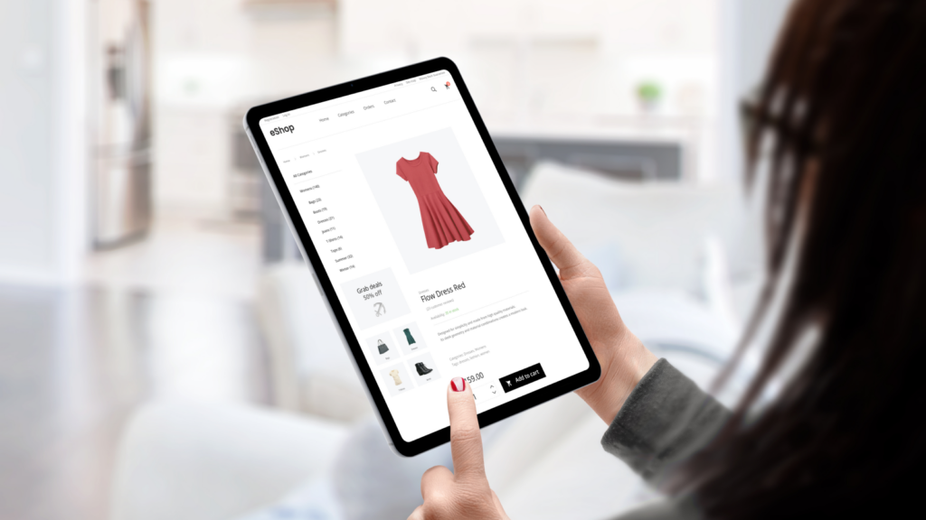 A woman choosing and ordering a dress in an online shop using a tablet.